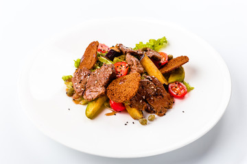 meat salad with roast beef, croutons, vegetables and potatoes on white background, isolated. Close-up