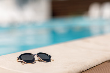 Fototapeta na wymiar sunglasses by the pool on a sunny summer day.