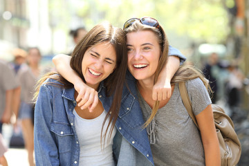 Two friends laughing loud in the street
