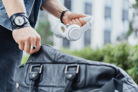 Close Up Of Man Putting Headphones In His Black Sports Bag