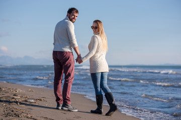 Loving young couple on a beach at autumn sunny day