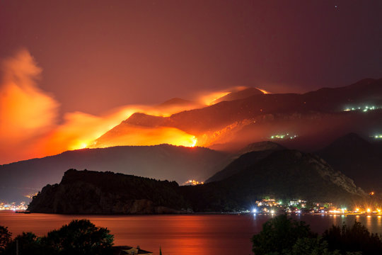 Wild Fire Blazing On Hills Above Sea Town.