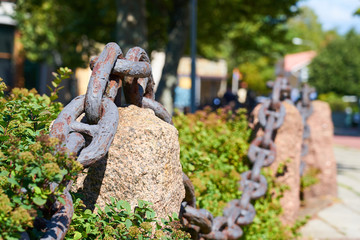 Naklejka premium Old metal rusty chain on the street with blurred background. 