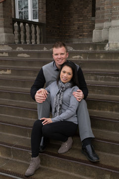 engaged couple smiling on wet steps