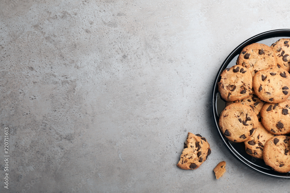 Sticker plate with chocolate cookies and space for text on gray background, top view