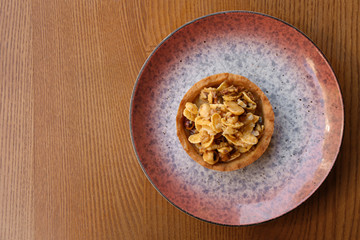 Plate with delicious cake on wooden table, top view