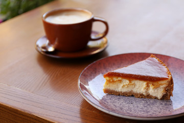 Plate with slice of cake on wooden table