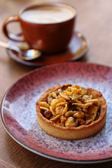 Plate with delicious cake on wooden table