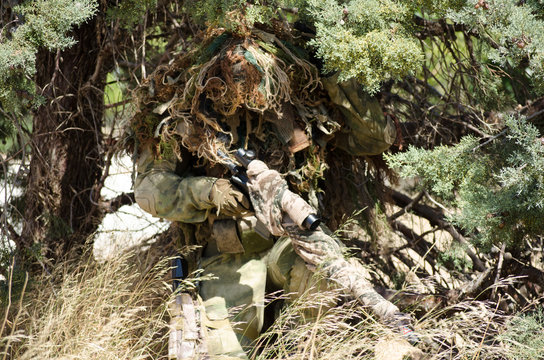 Sniper ghillie suit prepaire to take position hide in the trees