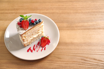 Piece of delicious homemade cake with fresh berries and space for text on wooden table