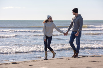 Loving young couple on a beach at autumn sunny day