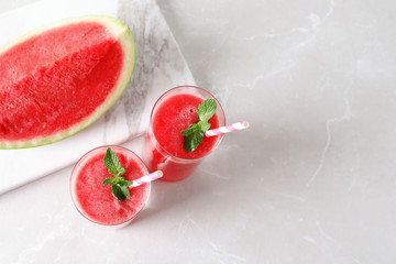 Tasty summer watermelon drink in glasses and fresh fruit on table. Space for text