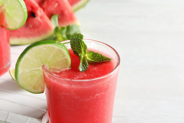 Tasty summer watermelon drink with lime and mint on table, closeup