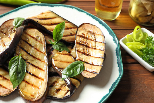 Plate with fried eggplant slices on table, closeup