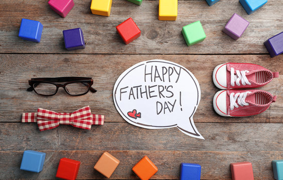 Flat lay composition with words HAPPY FATHER'S DAY, shoes and accessories on wooden background