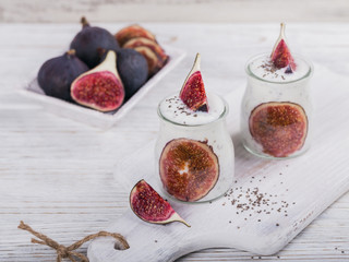 Homemade healthy yoghurt in glass jars with figs and chia seeds