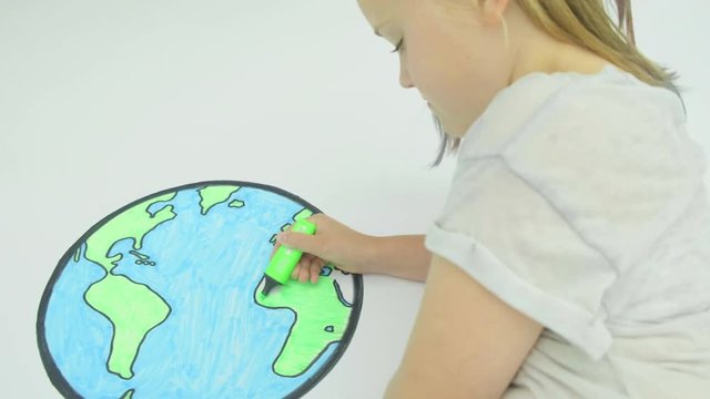 Pre teen caucasian girl colouring in a map of the world themes of environmental creativity curiosity concept drawing