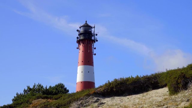 Wundersch&ouml;ner Leuchtturm H&ouml;rnum Sylt mit D&uuml;nen Landschaft  und blauen Himmel
