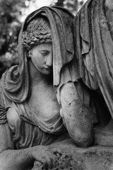Statue of woman on tomb as a symbol of depression and sorrow (faith, religion, Christianity, death concept)