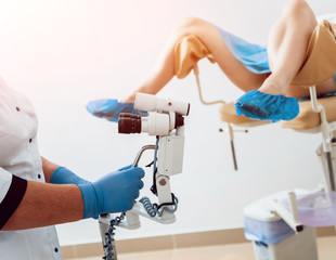 Gynecologist examining a patient with a microscope.