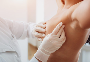 Doctor get examining breast of young woman. Consultation with gynecologist. - obrazy, fototapety, plakaty