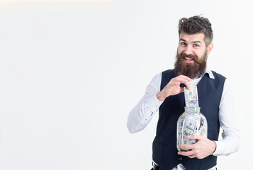 Saving money accounting concept. Banknotes. Dollars in glass jar. Man put dollars in jar. Business, finance&investment. Saving money by put in jar. Glass jar that is used by business man as piggy bank