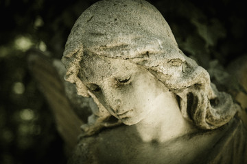 Face of beautiful angel. Close up of marble sculpture with a sweet expression that looks down.