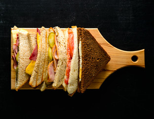 set of sandwiches, a series of cut sandwiches with various fillings on a wooden board