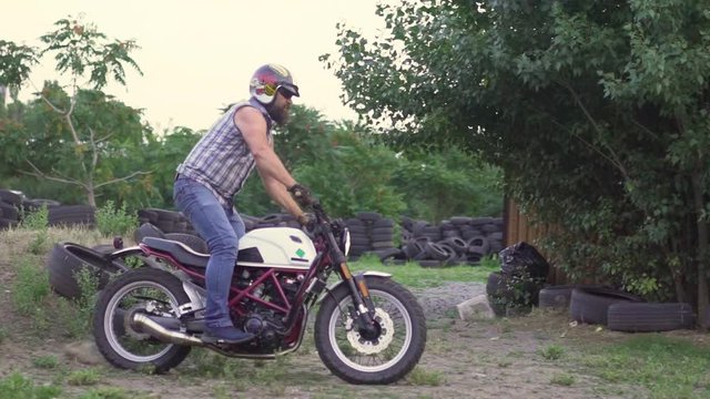 A professional motorcyclist rides a bike  and does various extreme tricks. Slow motion 120fps