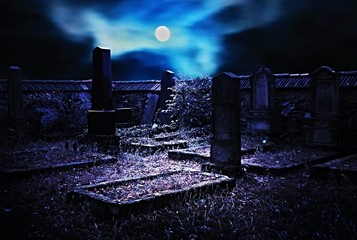 Old Jewish cemetery with stone tombstones, moonlit full moon. Scary night scenery.