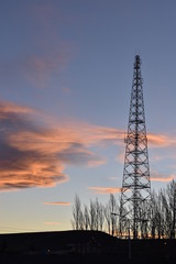 Antigua torre de microondas con el cielo del atardecer de fondo