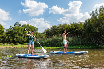 Man and woman stand up paddleboarding
