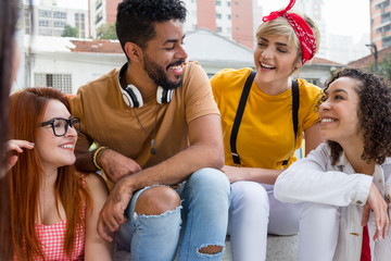 Mixed race group socializing in a party at restaurant outside. Summer, warm, friendship, diversity, reunion concept.