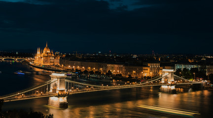 Fototapeta na wymiar Panoramic view of Danube river, Széchenyi Chain Bridge, and the Parliament building at night (long exposure, night trails) Budapest Hungary