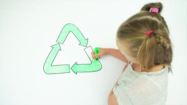 Caucasian girl colouring in an image of the recycling symbol environmental conservation symbol recycling protection