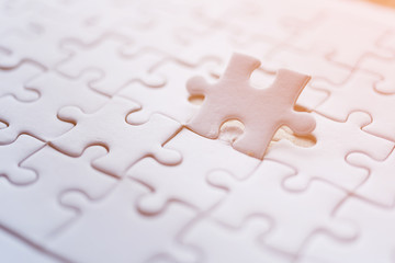 Fototapeta premium Jigsaw with one piece missing revealing orange background