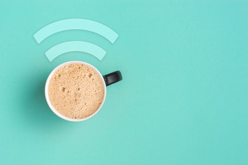 Cappuccino on pastel turquoise colored background with copy space.