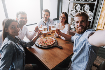 Cheerful Multiracial Friends Eating in Pizzeria. - obrazy, fototapety, plakaty