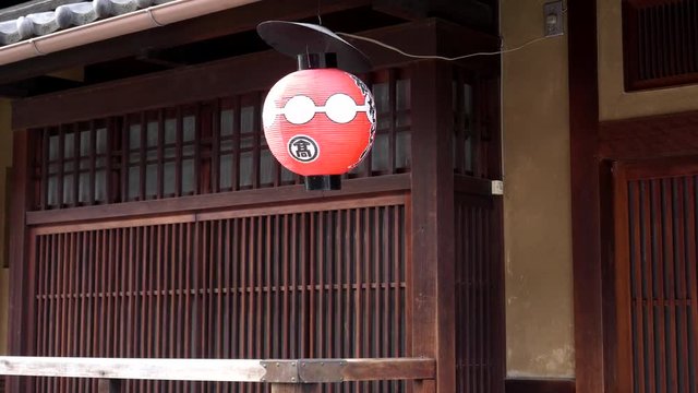 a red paper lantern outside a teahouse at the gion district of kyoto, japan
