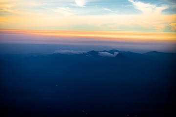 Background, high angle from the passenger plane. You can see the scenery by the distance (mountains, rivers, sky, fog, houses), the photos may be blurred during the flight.