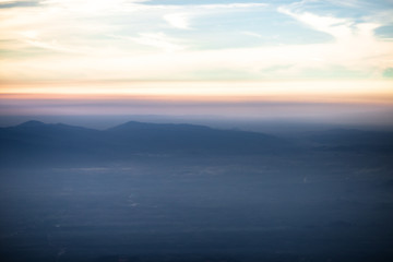 Background, high angle from the passenger plane. You can see the scenery by the distance (mountains, rivers, sky, fog, houses), the photos may be blurred during the flight.