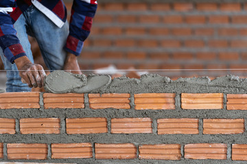 Closeup hand professional construction worker laying bricks in new industrial site. construct industry and masonry concept