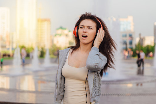 Young woman listening to music streaming with headphones.