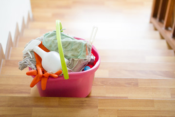 Cleaning tools in bucket on stair are prepare to cleaning whole house. House cleaning service and housekeeping concept.
