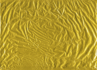 Shiny yellow gold crumpled wrapping paper foil texture for wallpaper decoration element background, stock photo image