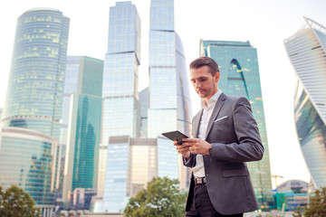 Young caucasian man holding smartphone for business work.