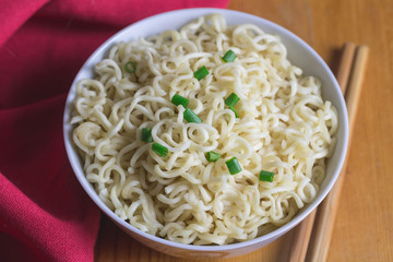 Noodles in bowl close up with selective focus - Quick plain noodle meal with chopped chives