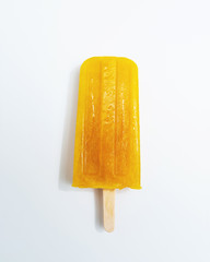 Ice lollies. Orange fruit ice cream presented on a white background with copy space. Top view