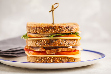 Ham, vegetables and cheese sandwiches on a white plate, white background.