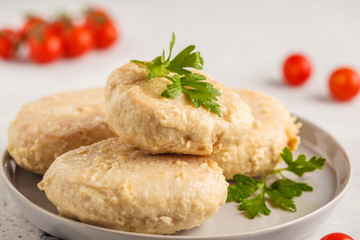 Steam chicken cutlet on a white plate, white background.